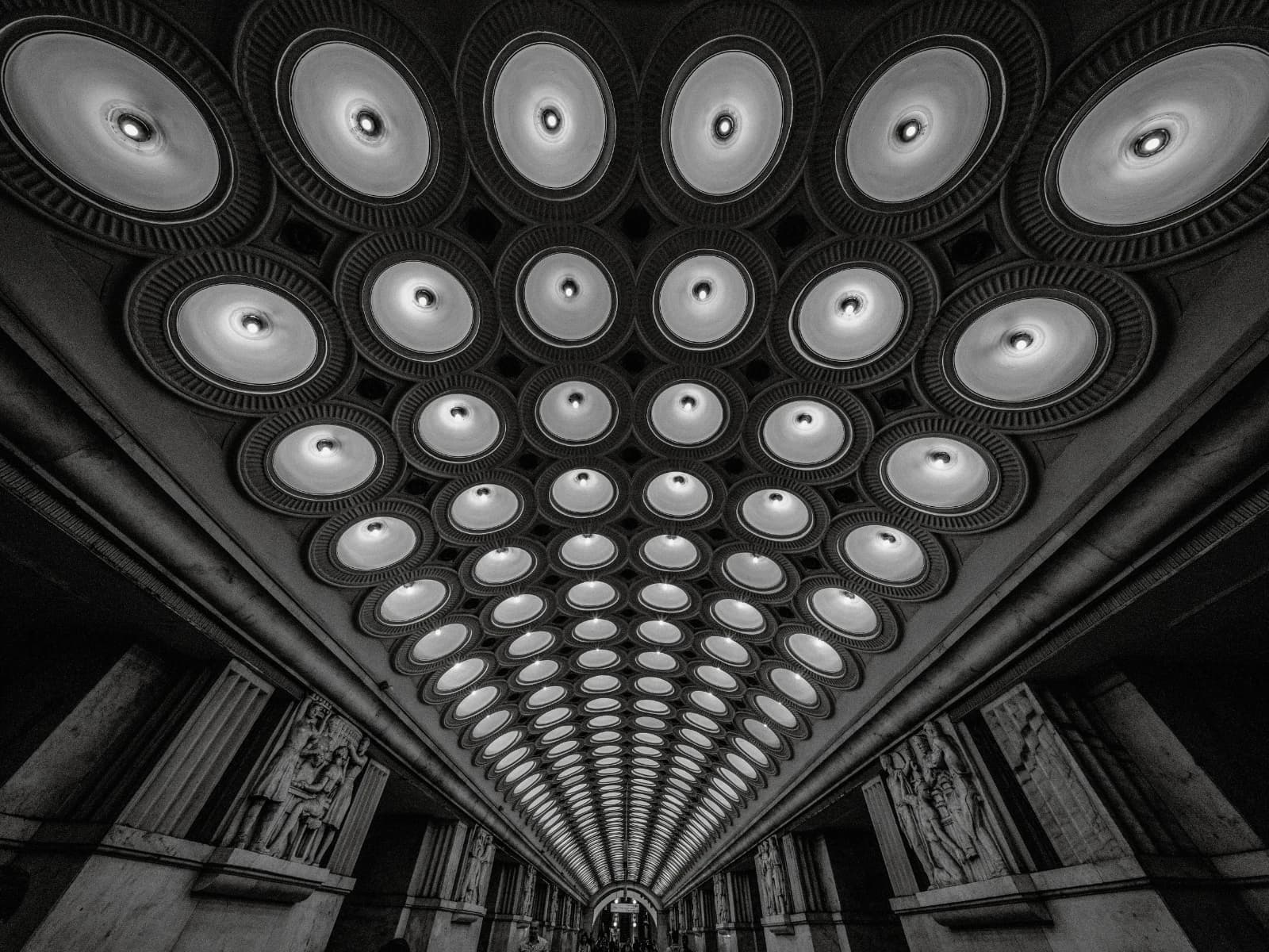A symmetrical Art Deco ceiling receding toward a distant archway